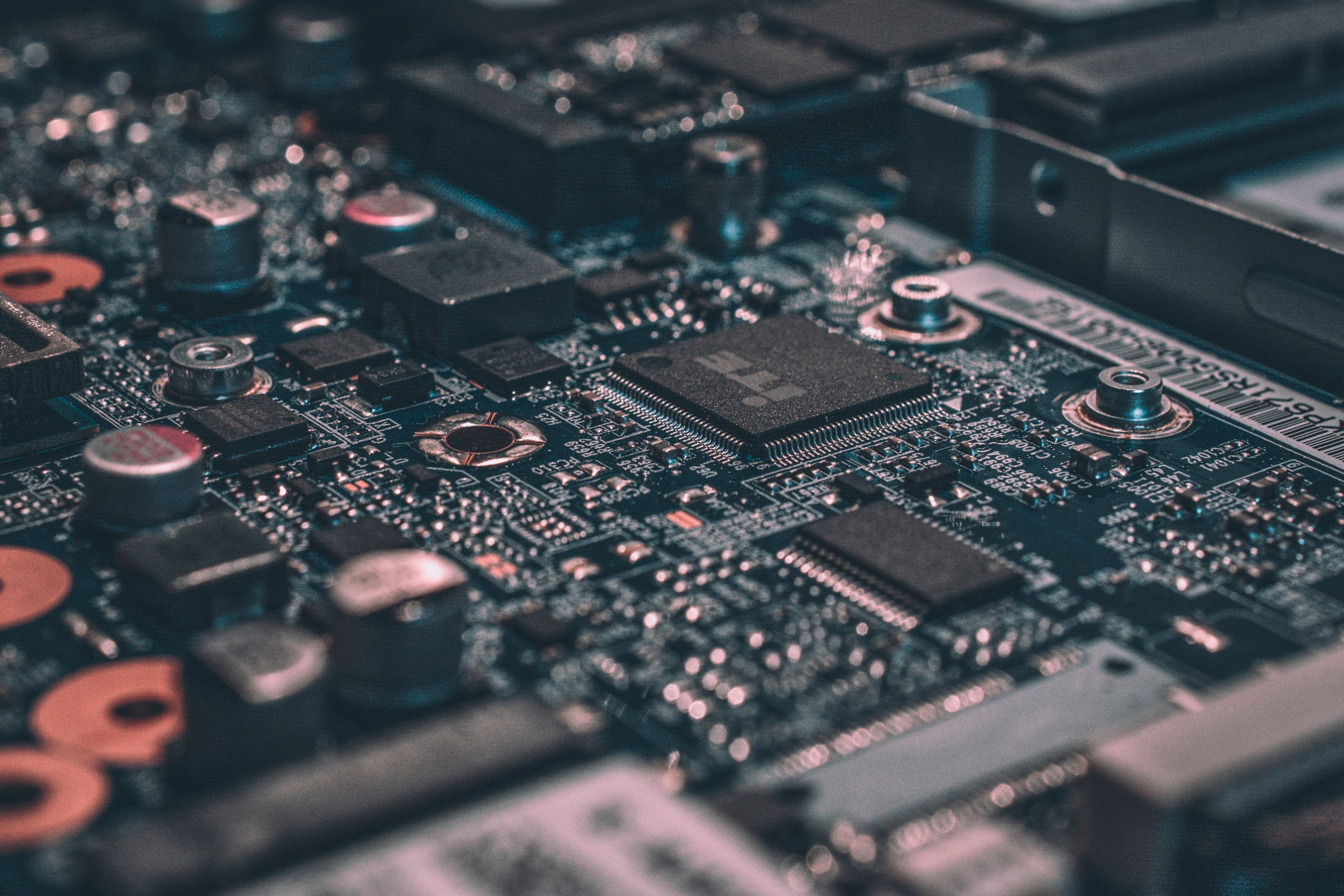 Macro close-up of a dark computer motherboard with gold circuit traces